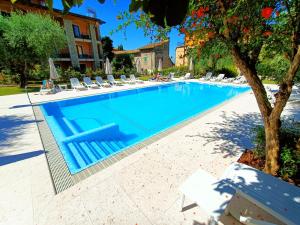 a large swimming pool with lounge chairs in a resort at Hotel Villa Isabella in Brenzone sul Garda