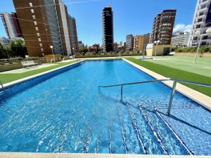 a large swimming pool in a city with tall buildings at Mediterraneo 43 - Aloturin Benidorm in Benidorm