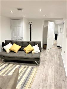 a living room with a gray couch and yellow pillows at Star Apartment in Ipswich