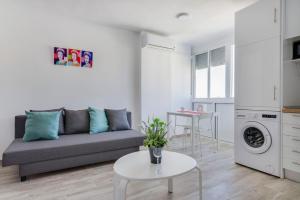 a living room with a couch and a table at Panoramic views cosy studio in Benalmádena