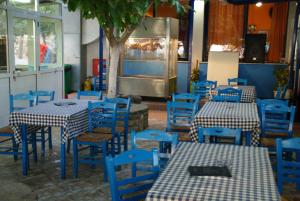 a restaurant with blue tables and blue chairs at Galazio Limani - Rooms to let in Moúdhros