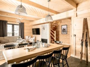 Ziębowe Domki في شوشولو: مطبخ وغرفة معيشة مع طاولة وكراسي خشبية كبيرة