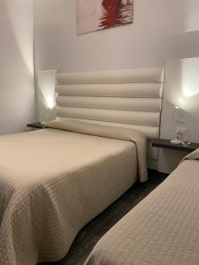 a hotel room with two beds and two lamps at Tysandros Hotel Apartments in Giardini Naxos