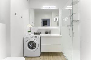 a white bathroom with a washing machine and a sink at Olimpijska 2 - City Apartments in Mielno