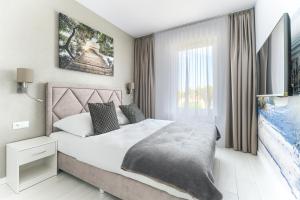 a bedroom with a large bed and a window at Olimpijska 2 - City Apartments in Mielno