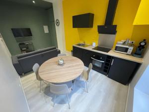 a kitchen with a wooden table and chairs in a room at Bel Appartement 40 M2 sans linge de lit et de toilette in Vals-les-Bains +8 photos