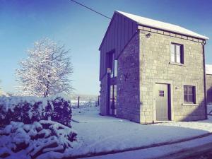 a small brick building with snow on the ground at Honey House in Foy-Notre-Dame