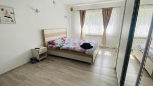 ein kleines Schlafzimmer mit einem Bett und einem Spiegel in der Unterkunft SunRise Apartament in Mangalia