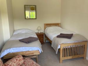 a room with two beds and a chair and a mirror at Meadowland Farm in Dolton
