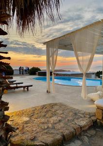 a resort patio with a canopy and a pool at Elafonisos Mare in Elafonisos