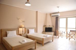 a bedroom with two beds and a living room at Lefkada Dikran's Guest House in Nydri