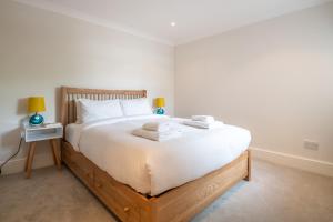 a bedroom with a large white bed with towels on it at Pleasant Putney home close to the tube station by UndertheDoormat in London