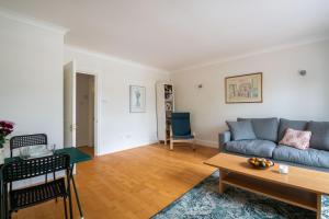 a living room with a couch and a table at Pleasant Putney home close to the tube station by UndertheDoormat in London