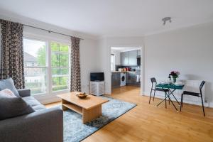 a living room with a couch and a table at Pleasant Putney home close to the tube station by UndertheDoormat in London
