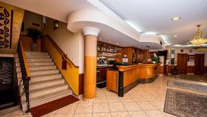 a lobby with a bar and a staircase at Hotel Villa Classica in Pápa