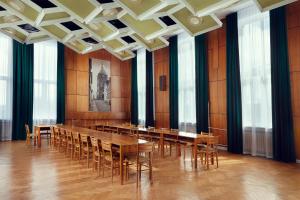 Stary Koszalin Hostel & Hotel Services في كوشالين: قاعة المؤتمرات مع طاولة وكراسي طويلة