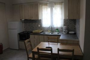 a kitchen with a table and chairs and a sink at Chloe Apartments in Tsoukaladhes