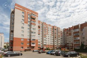 ヴォログダにあるApartment 2Pillows Leningradskaya 144の駐車場付きの大型アパートメントビル