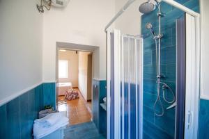 een badkamer met een douche en een blauwe muur bij Il Panorama Housing Cilento in Santa Maria di Castellabate