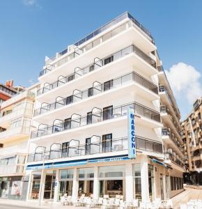 a white building with tables and chairs in front of it at Hotel Marconi in Benidorm