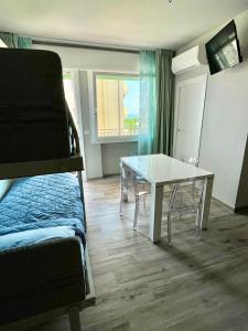 a room with a table and a bed and a table and a bed at Karpa House in Sottomarina