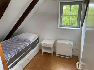 a small bedroom with a bed and a window at Liebevoll eingerichtetes Ferienhaus mit großem Garten in Clausthal-Zellerfeld