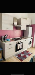a kitchen with white cabinets and a stove top oven at B&B La Caldosa in Olbia