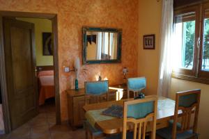 - une salle à manger avec une table, des chaises et un miroir dans l'établissement Pago de Yuste - Casa Rural Apartamentos, à Cuacos de Yuste