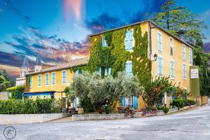 a building covered in ivy on a street at Logis hôtel et restaurant La Bastide Cabezac in Bize-Minervois