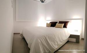 un lit blanc dans une chambre blanche avec une fenêtre dans l'établissement Beautiful apartment close to the sea, à Arenales del Sol 10 autres photos