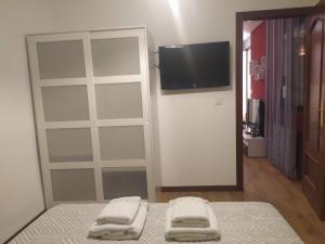 - une chambre avec un lit, une télévision et un miroir dans l'établissement Vivienda de Uso Turistico Ramos 3, à Cuenca