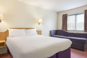 a hotel room with a bed and a chair at Days Inn Chesterfield - Tibshelf in Tibshelf