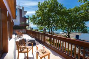 uma varanda com cadeiras e uma mesa e vista para o oceano em Mala Garden Design Hotel em Siófok