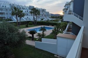 uitzicht op het zwembad vanaf het balkon van een gebouw bij MET&GOLF OLIVA NOVA BEACH in Oliva