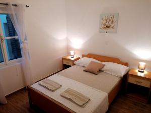 niewielka sypialnia z łóżkiem i 2 szafkami nocnymi w obiekcie Apartments Amfora w mieście Gdinj