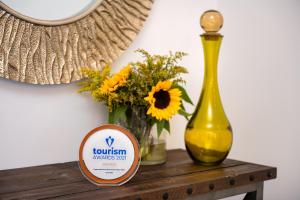 a table with a yellow vase and flowers on it at Siete Mares Luxury Suites in Imerovigli