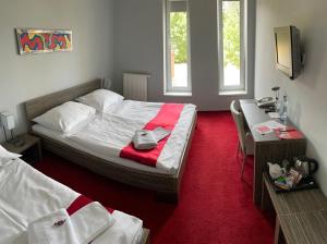 a hotel room with a bed and a desk with a desk at Hotel Olympia in Kopřivnice +26 photos