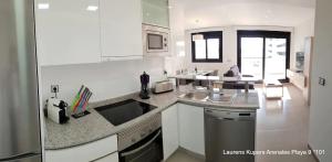 une cuisine blanche avec un évier et un comptoir dans l'établissement Beautiful apartment close to the sea, à Arenales del Sol