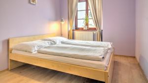 a bedroom with a wooden bed with a window at Boromeum Residence in Hradec Králové