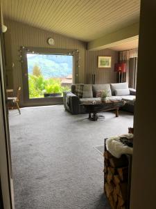 a living room with a couch and a window at Magnifique Maison près du centre in Nendaz