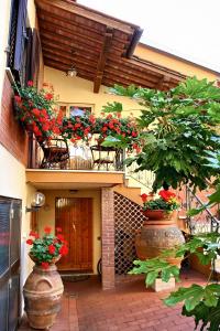 2 jarrones grandes con flores rojas en el balcón en Primettahouse, en San Gimignano