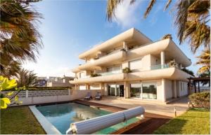 une grande maison avec une piscine en face de celle-ci dans l'établissement VILLA BLANCA, La MANGA, POOL& SEA San Javier, Murcia, à La Manga del Mar Meno
