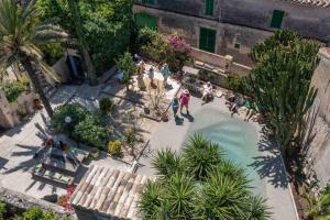 a group of people standing around a swimming pool at León de Sineu in Sineu