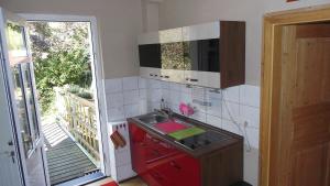 a kitchen with a sink and a red cabinet at Ferienwohnung-zur-Eselsbruecke in Rathmannsdorf