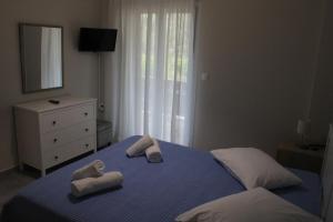 a bedroom with two towels on a blue bed at Chloe Apartments in Tsoukaladhes