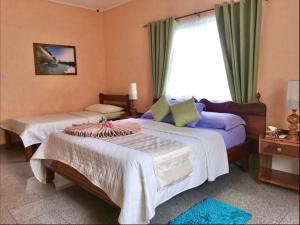 a bedroom with two beds and a window at Villa Bananier in Baie Sainte Anne