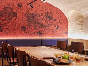 a table in a restaurant with a red wall at Ibis Styles Paris Gare de l'Est Magenta in Paris