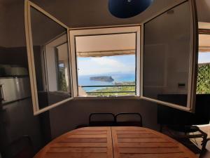 a room with a wooden table and a window at Arcomagno Guest House in San Nicola Arcella