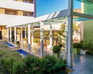 un patio de un edificio con toldo y plantas en ALTO PADRÃO! Shop. Estação. Piscina, sauna, academia. NOVO!, en Curitiba