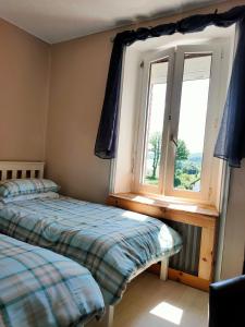 a bedroom with two beds and a window at Gouarec Bed & Breakfast in Gouarec